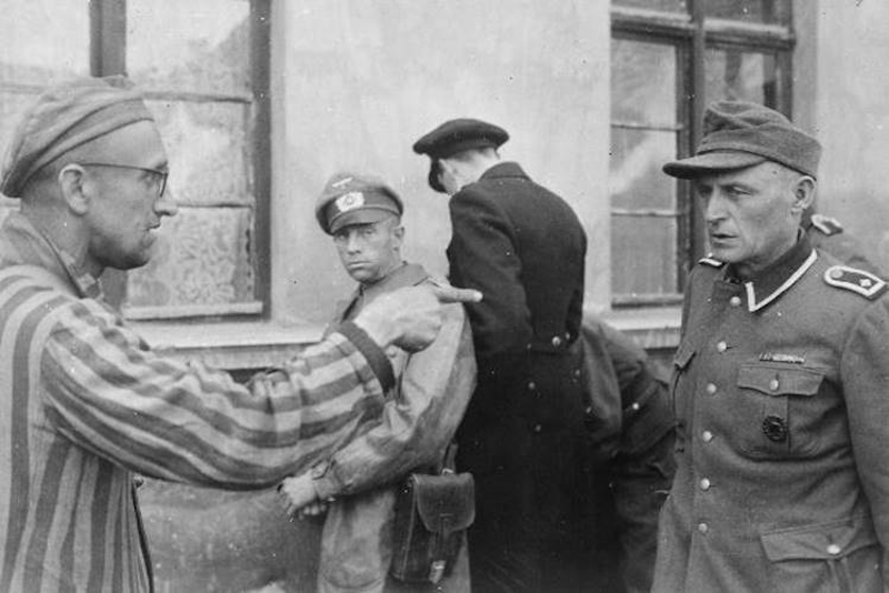 Uno schiavo lavoratore russo liberato dalle forze U.S.A. indica una ex guardia nazista che picchiava brutalmente i prigionieri. 14 maggio 1945, Germania, autore sconosciuto o non fornito © courtesy U.S. National Archives and Records Administration