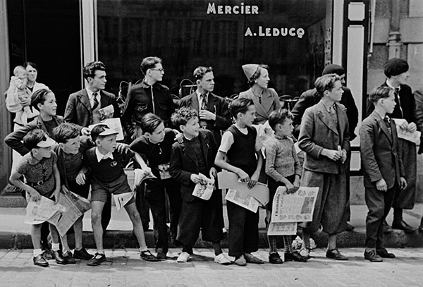 Robert Capa A crowd gathered in front of Mr. Pierre Cloarec’s bicycle shop